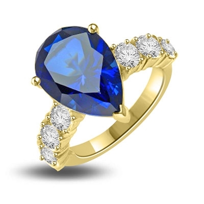 Diamond Essence Designer Ring with 5.50 cts. Pear Cut Sapphire Essence in center and three round stones on each side of center. 7.0 Cts. T.W. set in 14K Solid Yellow Gold.