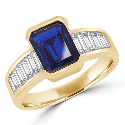 Escape with this Wide Band Ring with Channel Set Emerald Cut Sapphire Essence, 2.5 cts. separated by straight Diamond Bright Baguettes set vertically for a totally magnificent effect. 3.5 cts.T.W. set in 14K Solid Yellow Gold.