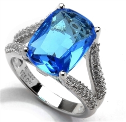 Diamond Essence Ring with 6 Ct. Blue Cushion Cut Stone and Melee on band, 6.15 Cts.T.W. in Platinum Plated Sterling Silver.