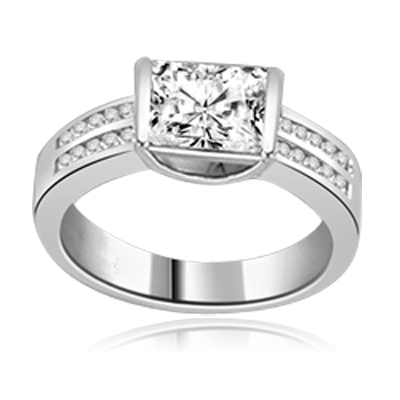 A unique East-West design, with a Channel Set 1.5 Ct. Radiant Emerald Cut Diamond Essence Center and a bevy of Melee accents down the band for an exhilarting sensation, in Platinum Plated Sterling Silver.