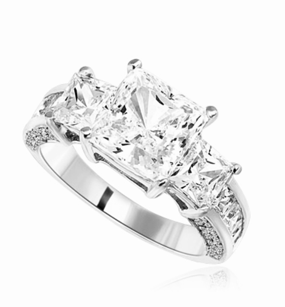Three Stones Sparkling Ring With Princess Cut Diamond Essence Set in center accompanied by Princess Cut Diamond Essence on each side with channel set Princess stones on band and Melee on side of the band. 3.25Cts T.W. set in Platinum Plated Strling Silver