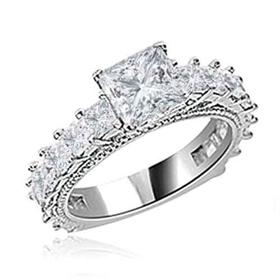 Diamond Essence Designer Ring With 1.50 Cts. of Princess in Center, Accompanied by Small Princess Stones Melee on band, 3 Cts.T.W. In Platinum Plated Sterling Silver.