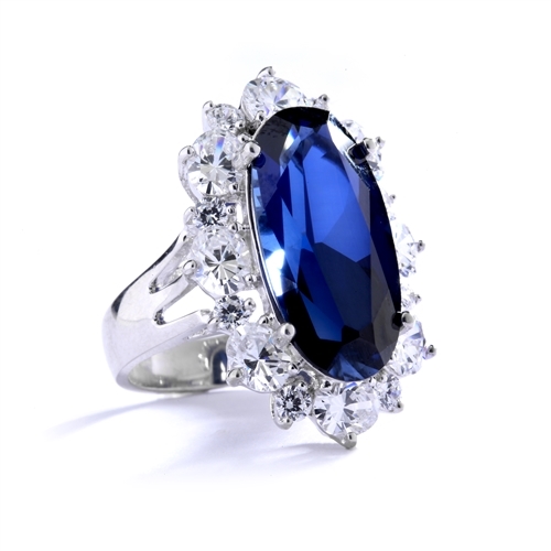Sapphire Ring - 13 Cts. Long Oval cut Sapphire Essence set in center surrounded by Oval Diamond Essence and Melee. 16.0 Cts. T.W. set in Platinum Plated Sterling Silver.