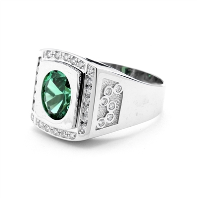 An impressive Men's Ring in two-toned 14K White Gold features a 4.0 cts. Oval Emerald stone set flush in a platform of white gold surrounded by melee, with double jolts of melee on each shank. 4.50 cts. t.w.