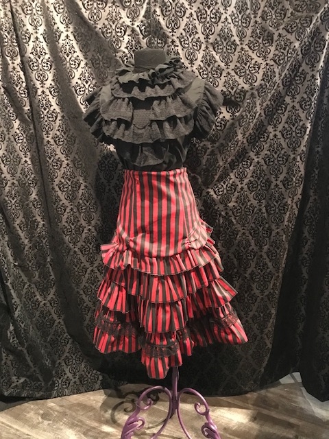 Erin Skirt is done in our Red and Black Striped Fabric and features many Layered Ruffles and a Side Zipper. This Victorian-inspired Below the knee skirt is fully lined with a 100% Polyester Lining.