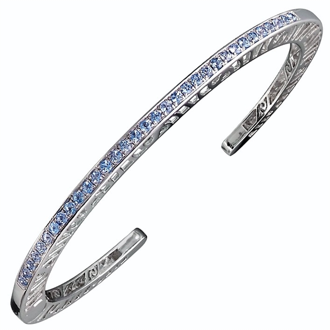 Narrow stacking Bangle inlaid with 33 Swiss Blue Topaz Gemstones (2ctw). Open work design along the side edges - pierced with designer Martha Seely's signature interlocking spirals. Hinged on one side for ease of fit. 4mm Wide. Rhodium plated solid 925 SS