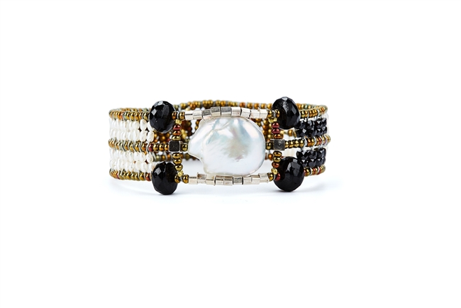 A single, large Baroque Pearl, accented at each corner by Black Onyx Gemstones, is the focus of this Cuff Bracelet by Ziio.  White Seed Pearls create the band with Murano Glass Beads. 925 Sterling Silver Button Closure.  Adjustable in lenght 7" to 7 1/2"