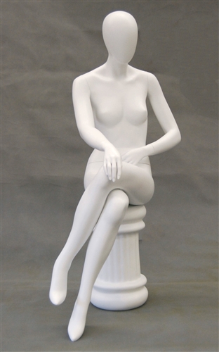 Female egghead mannequin in seated pose. Her legs are crossed with her hands on her lap.