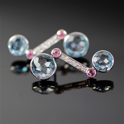 Imperial Icicle Earrings photo. Like the Imperial Icicle Ring, these are made from 18k white gold, giving it a special unique appeal. Two, round, shiny, blue topaz stones at each end and 2 smaller pink tourmalines along with the diamonds on the shaft.