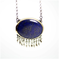 Bright blue lapis is set in bezel of 18k gold back with sterling silver.