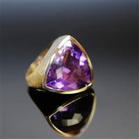 Cosmic Violet Ring photo. This flawless beauty engages the eye like no other, its feel is amazing as well. The round triangular shape of the shiny, purple Amethyst is a super power. the 18K gold helps bring in the focus to the piece. Details inside.