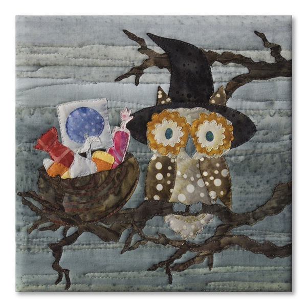 Quilt block of a wide-eyed owl and its nest full of candy