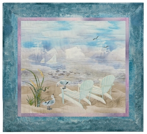 Quilt block of two Adirondack chairs on the beach, looking out at sailboats on the ocean.