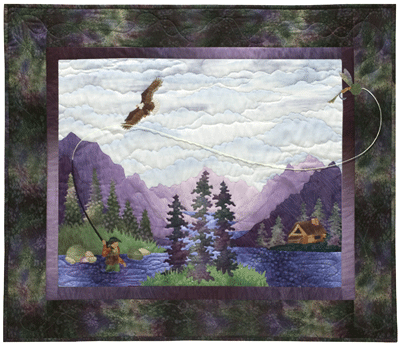 Quilt block showing a fisherman standing in a river casting a fly, with an eagle flying overhead. The riverside cabin and large purple mountains are in the background.