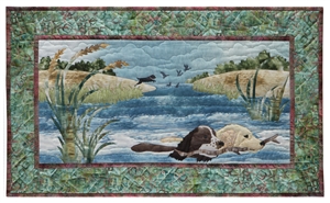 Quilt block of two dogs carrying a stick as they swim through a stream together.