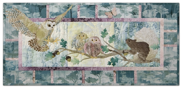 Quilt block of an owl landing on a branch next to her babies, startling a squirrel