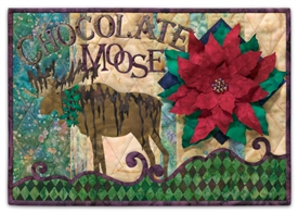 This quilt block is a play on words, as a moose drizzled with chocolate stands near a large, probably inedible, poinsettia.