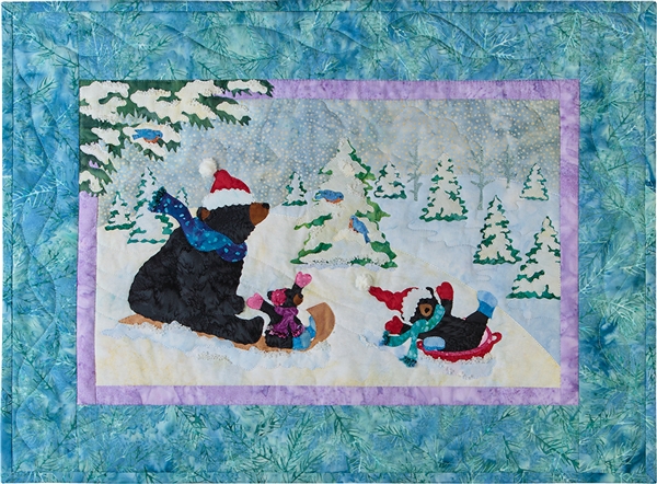 A quilt block with mama bear and her two babies sledding down a snowy hill.