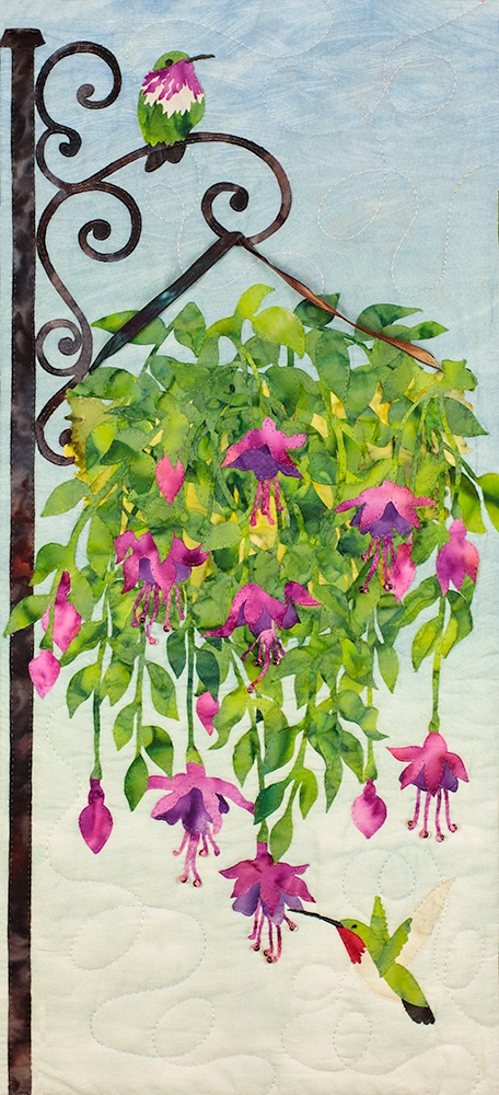 Fabric art print of hummingbirds drinking nectar from a hanging plant.