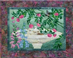 Quilt block of two birds making a splash in a bird bath.