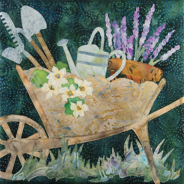 A quilt block featuring a wheel barrow full of gardening tools, flowers and a pot full of lavender.