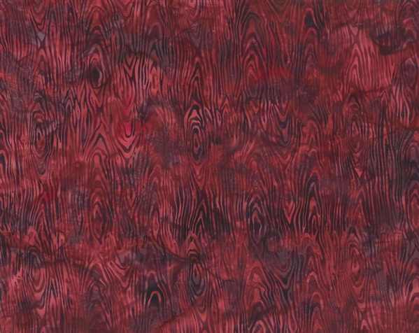 Batik fabric print of wood grain in shades of red and maroon.