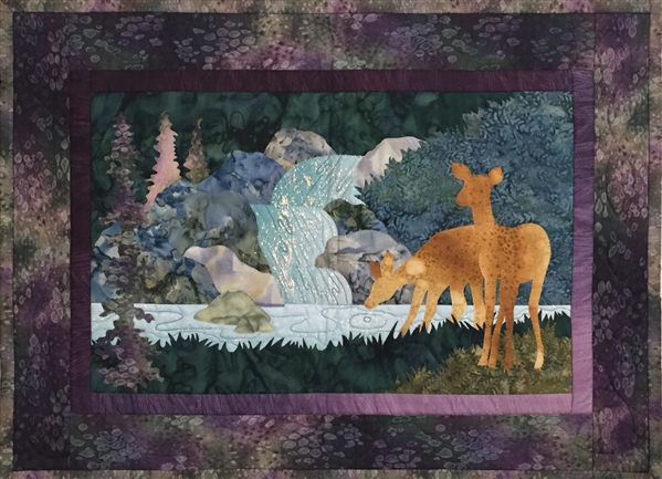 Quilt block of a doe with her fawn carefully drinking from the stream below a small waterfall.