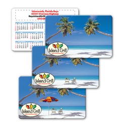 Lenticular calendar card with palm trees, umbrella, and lawn chair appear on a tropical Hawaiian beach, flip
