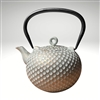 Image of the "Dim" cast iron teapot by Ja by Frieling. This teapot has a textured and handpainted exterior in a gold and mint circle pattern. The image shows the black handle.