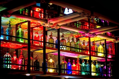 Wall of 54 Seltzers | The Seltzer Shop | Colored Argentine seltzer bottle - vintage seltzer pendant light - wine chiller interior design elements
