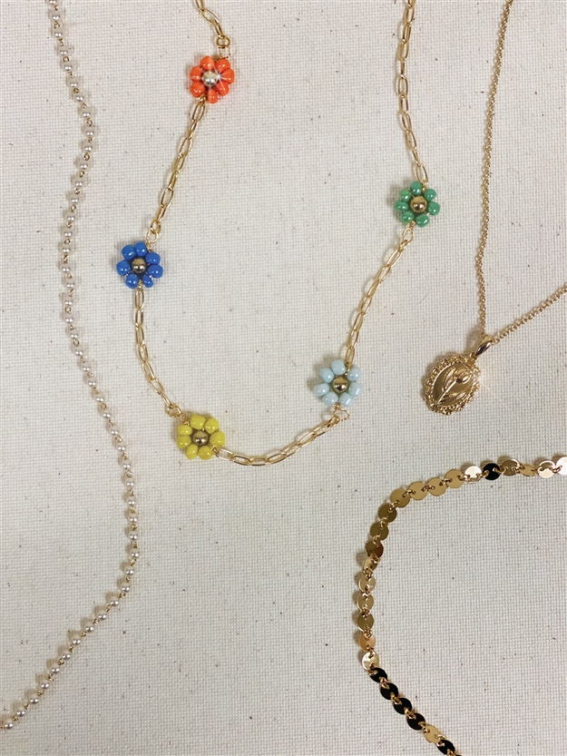 Four different Mirajo Jewelry necklaces including  becoming flower necklace on light background