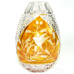 This is genuine Polish hand-cut leaded crystal with a hummingbird and floral design. Amber colored background.