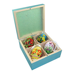 Set of 4 hand painted Polish chicken eggs (blown) in a hand painted display box.   This set is on sale due to what appears to be a pen line on the front left side of the box which can be seen in the first two pictures.   Each of the eggs has its own ribb