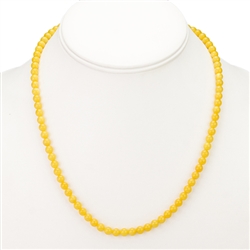 This beaded amber necklace features small round Baltic milky amber beads strung together, and finished with a gold claw clasp. The beads are not knotted between each bead.