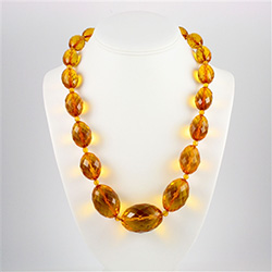 Stunning necklace composed of clear honey amber oval beads, faceted and graduated in size.  Each piece is separated by a smaller amber bead.