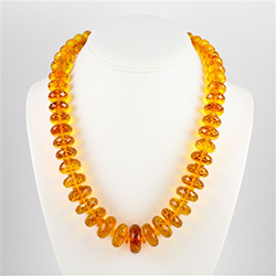 Stunning necklace composed of clear honey amber "wheels" faceted and graduated in size.  Each piece is separated by a smaller amber bead.