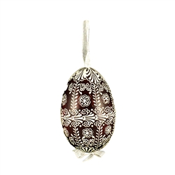 This beautifully designed egg is dyed one color, then white wax is melted and applied to form an intricate design which is left on the surfce. The egg is emptied and strung with ribbon for hanging.