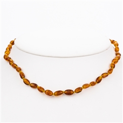 Lovely necklace composed of cognac colored amber.. Gold colored cord w/ knot between each bead. Perfect size for children over three. Definitely not intended for children 3 or younger due to the small parts and choking hazard.