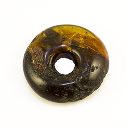 Very impressive polished doughnut shaped honey amber stone for pendant use. Weighs 9.7g. This amber stone is mainly polished but also has natural rough spots to highlight its natural origins.