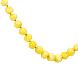 This beautiful beaded amber necklace features small rounded Baltic custard color amber beads strung together, and finished with an amber closure. The beads are knotted between each bead.
