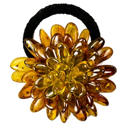 This amber "flower" is compose of multiple polished beads sewn together with a knitted back. Attached with a stretch band.