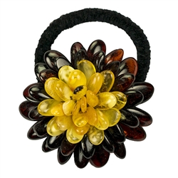 This amber "flower" is compose of multiple polished beads sewn together with a knitted back. Attached with a stretch band.