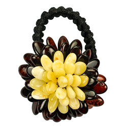 This amber "flower" is compose of multiple polished beads sewn together with a knitted back. Attached with a stretch band.