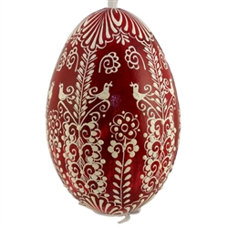 This beautifully designed egg is dyed one color, then white wax is melted and applied to form an intricate design which is left on the surfce. The egg is emptied and strung with ribbon for hanging.