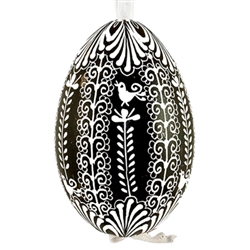 This beautifully designed egg is dyed one color, then white wax is melted and applied to form an intricate design which is left on the surfce. The egg is emptied and strung with ribbon for hanging.