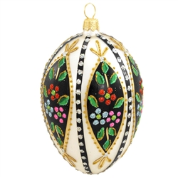 Add a glistening addition to your holiday decor with this beautiful egg! Crafted of glass in Poland and painted a cream white, this 4" egg is accentuated with vibrant green, black and gold glazes, and dazzling gold, green, red, silver, blue and pink