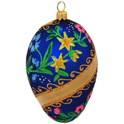 Our elegant egg ornament features gold swirls on a matte blue finish. Crafted of glass accentuated with beautiful flowers lavishly coated in dazzling glitter, this 3¾" tall unique egg will make the perfect addition to any holiday décor!