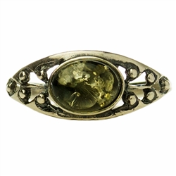 A small oval of green color amber set in a classic sterling silver setting. Size approx .25" x .4"