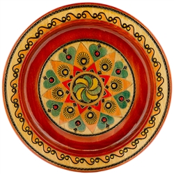 This Polish plate is made from beech wood in the mountain region of southern Poland called Podhale. The plates are cut and shaped on a lathe by hand. The designs are burned into the wood then painted after staining and varnishing. All the designs are