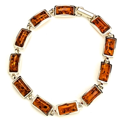 11 rectangular shaped amber beads each set in a sterling silver frame. 7.25" long.